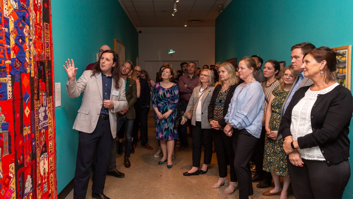 A group stands in a hallway looking at art